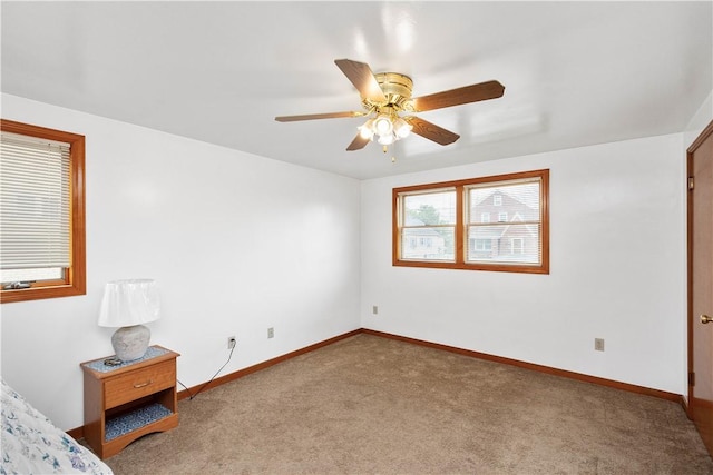 unfurnished bedroom with carpet, baseboards, and ceiling fan