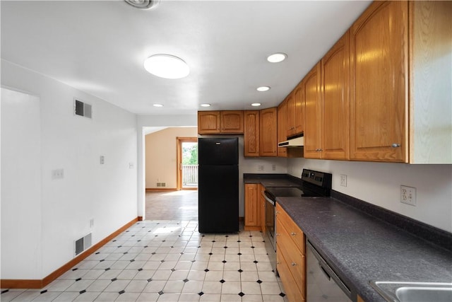 kitchen featuring visible vents, dark countertops, appliances with stainless steel finishes, brown cabinets, and under cabinet range hood