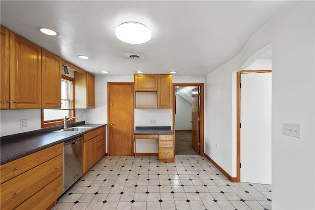 kitchen with dishwasher, dark countertops, a sink, and visible vents