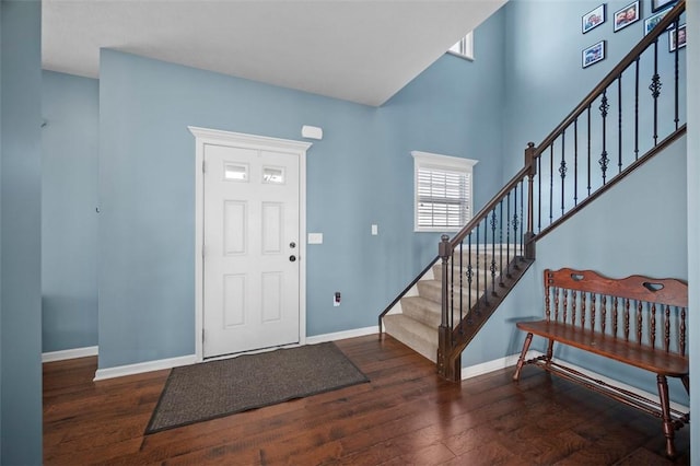 entrance foyer with a high ceiling, stairs, baseboards, and wood finished floors