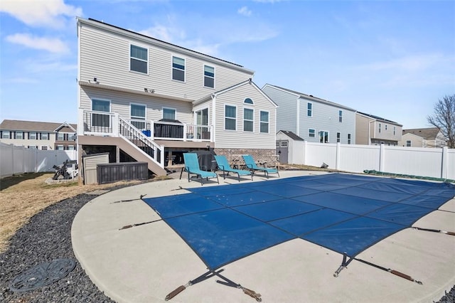 back of property with a fenced backyard, stairway, a wooden deck, a fenced in pool, and a patio area