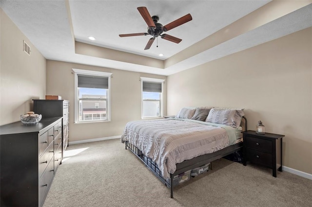 carpeted bedroom with recessed lighting, a raised ceiling, visible vents, ceiling fan, and baseboards