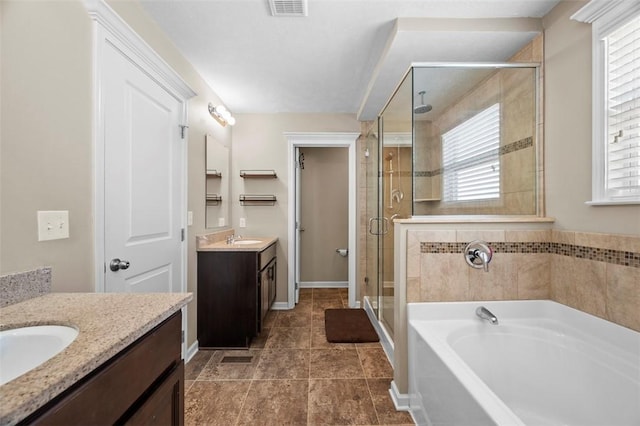 full bath featuring two vanities, a sink, a bath, and a shower stall