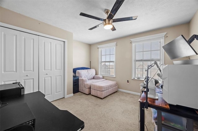 office featuring a ceiling fan, carpet, baseboards, and a textured ceiling