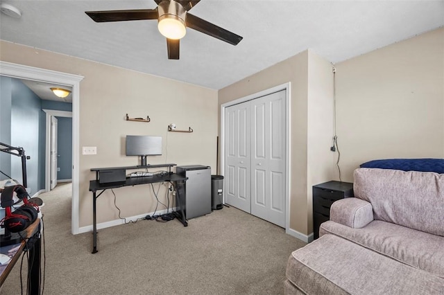 carpeted home office with ceiling fan and baseboards