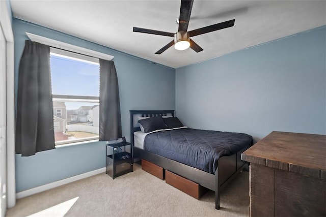 carpeted bedroom with ceiling fan and baseboards