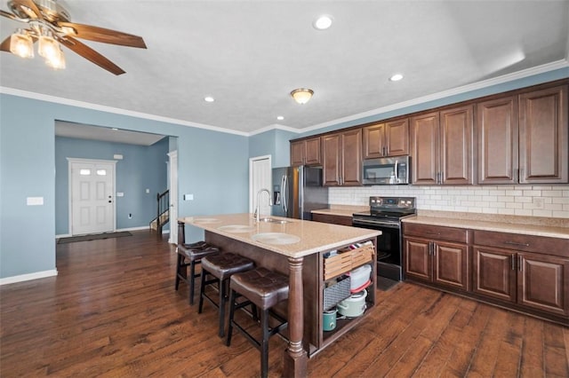 kitchen with appliances with stainless steel finishes, a breakfast bar area, dark wood finished floors, and decorative backsplash