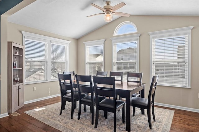 dining area with dark wood-style floors, vaulted ceiling, baseboards, and ceiling fan