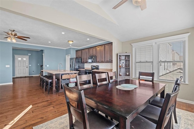 dining room featuring lofted ceiling, ornamental molding, wood finished floors, and baseboards