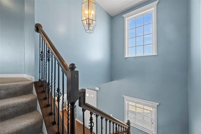 stairs with baseboards and a notable chandelier