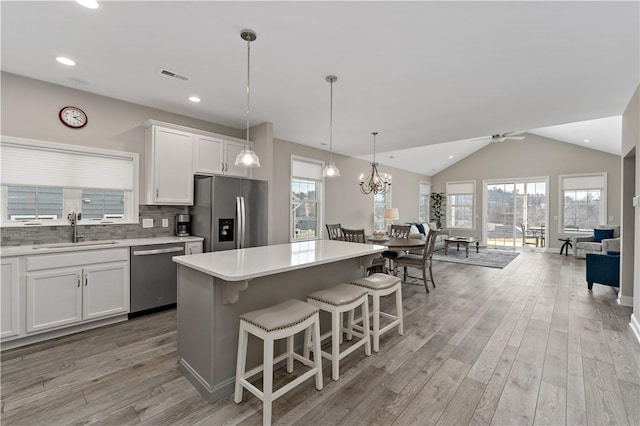 kitchen with visible vents, open floor plan, light countertops, stainless steel appliances, and a sink