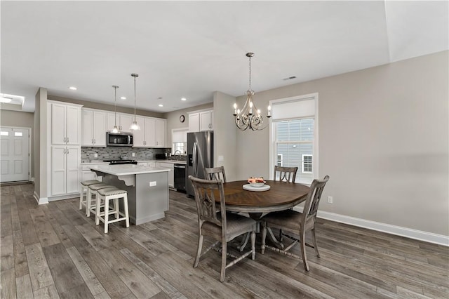 dining area featuring a chandelier, recessed lighting, dark wood-style flooring, and baseboards