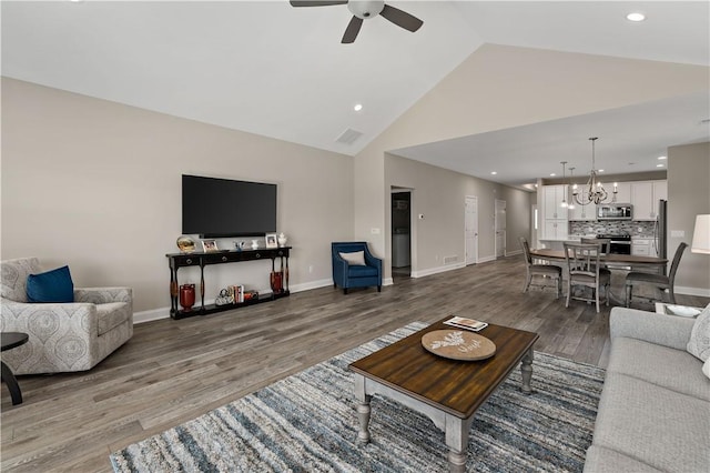 living area featuring recessed lighting, baseboards, wood finished floors, and ceiling fan with notable chandelier