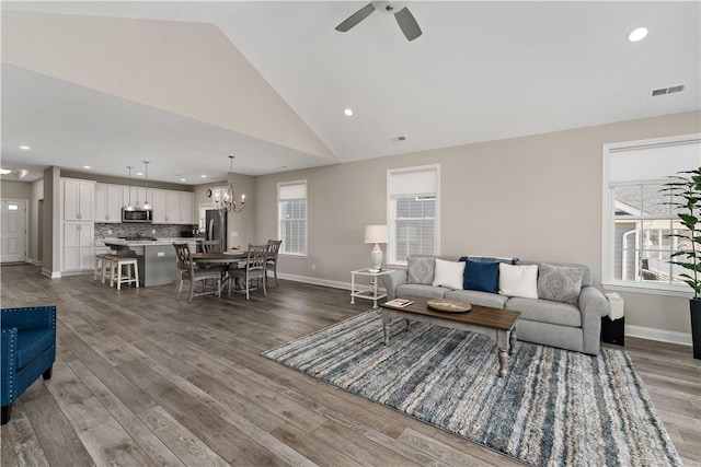 living room featuring baseboards, visible vents, dark wood-type flooring, and a wealth of natural light