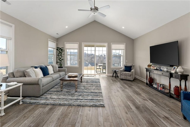 living area with ceiling fan, high vaulted ceiling, wood finished floors, visible vents, and baseboards