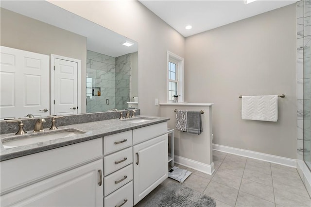 bathroom featuring a stall shower, baseboards, and a sink