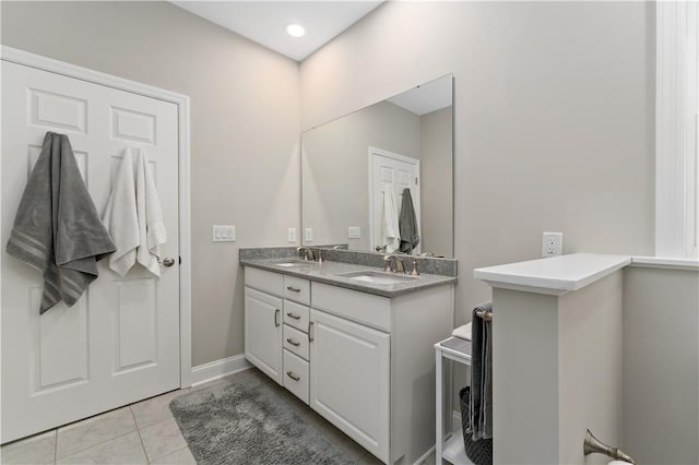 bathroom with tile patterned flooring, a sink, and double vanity