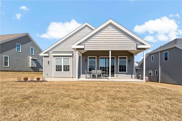 rear view of house with a patio area and a lawn