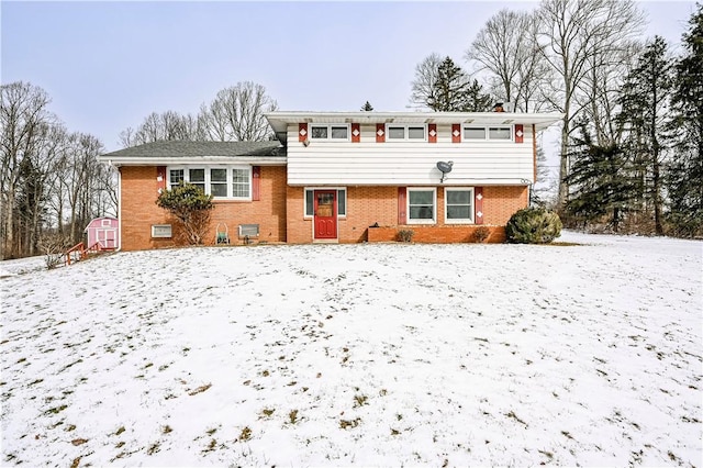 tri-level home featuring an outbuilding and brick siding