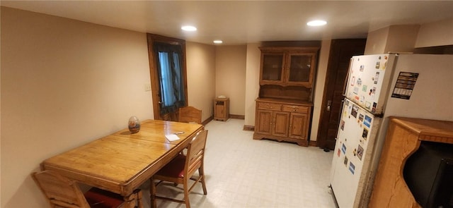 interior space featuring baseboards, light floors, freestanding refrigerator, and recessed lighting