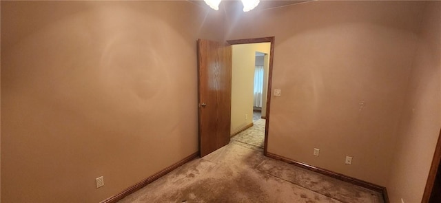 interior space with baseboards and light colored carpet