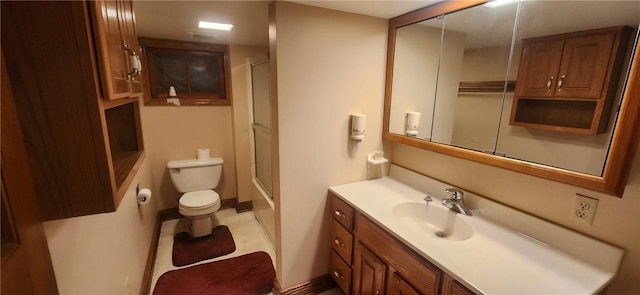 bathroom featuring a shower with shower door, vanity, toilet, and baseboards