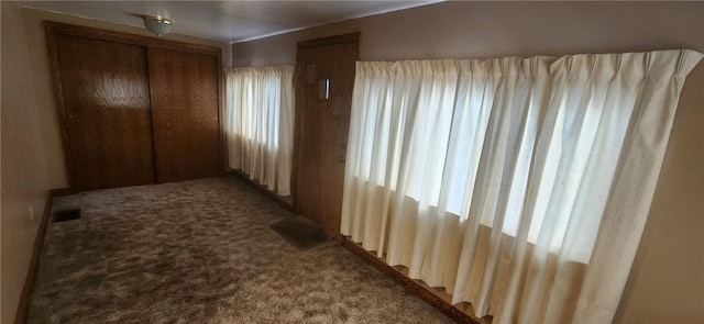 hall featuring a wealth of natural light, carpet, and visible vents