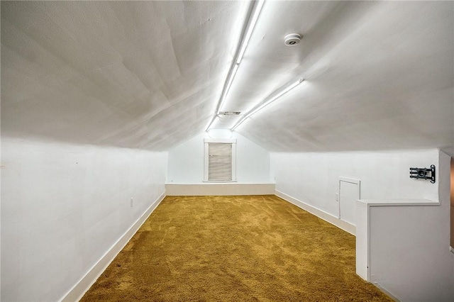 bonus room featuring lofted ceiling, carpet flooring, and baseboards