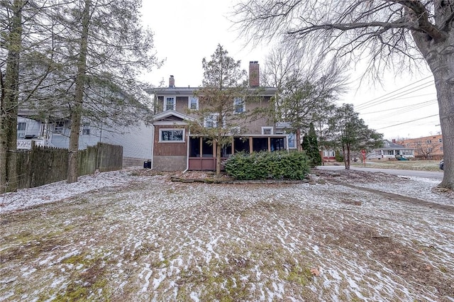 back of property featuring a chimney and fence