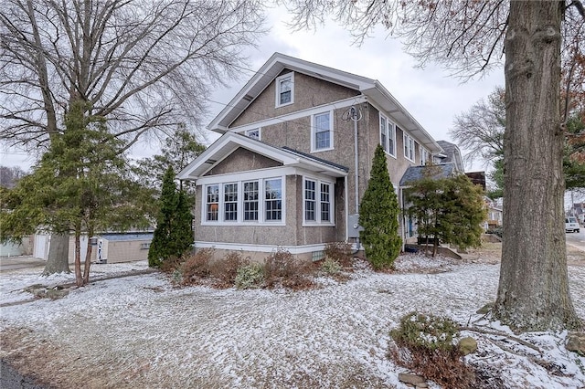 snow covered property featuring stucco siding