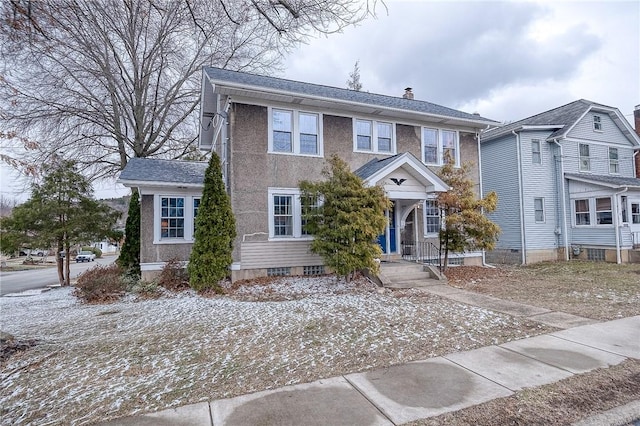 view of front of home with a chimney and stucco siding