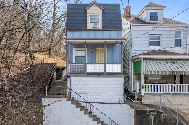 view of front of home with roof with shingles, a porch, and stairway