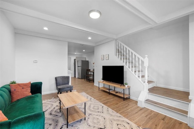 living room with baseboards, stairway, beam ceiling, and wood finished floors