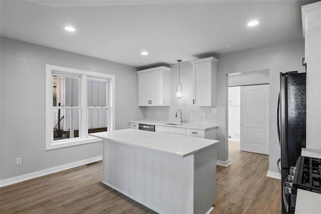 kitchen featuring white cabinets, dishwasher, range with gas cooktop, light countertops, and a sink