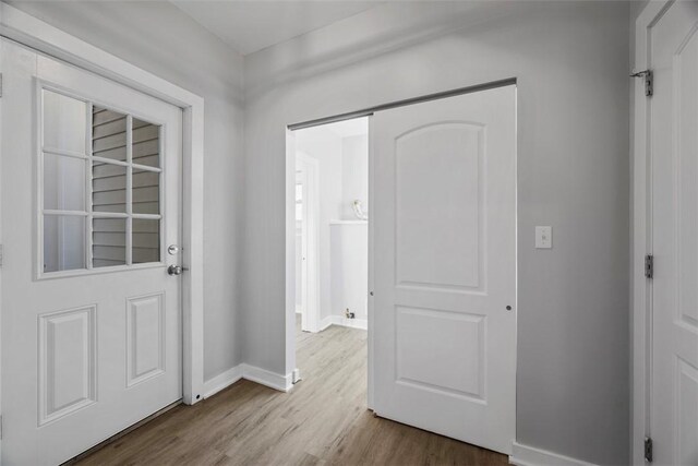 foyer entrance featuring baseboards and wood finished floors