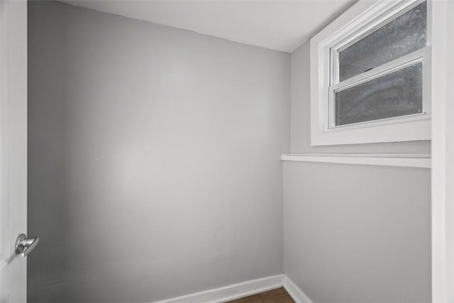 empty room with dark wood finished floors and baseboards