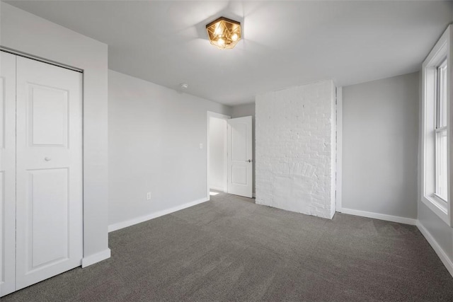 unfurnished bedroom featuring dark carpet and baseboards