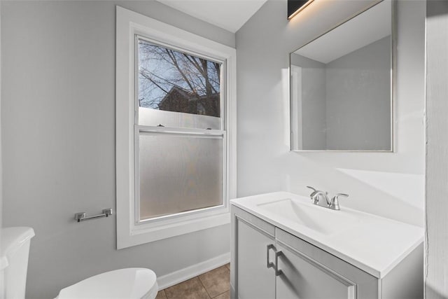 bathroom featuring tile patterned flooring, baseboards, vanity, and toilet