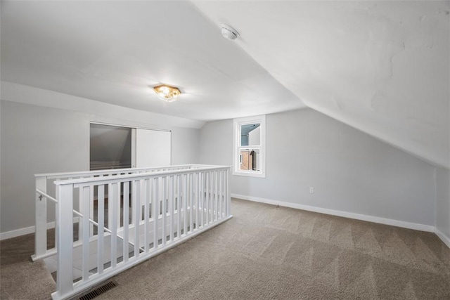 additional living space featuring vaulted ceiling, carpet, and baseboards