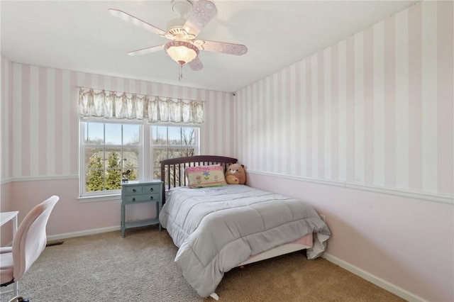 carpeted bedroom with a ceiling fan, baseboards, and wallpapered walls