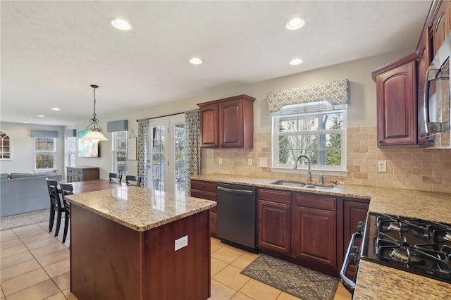 kitchen featuring stainless steel microwave, open floor plan, a kitchen island, a sink, and dishwasher