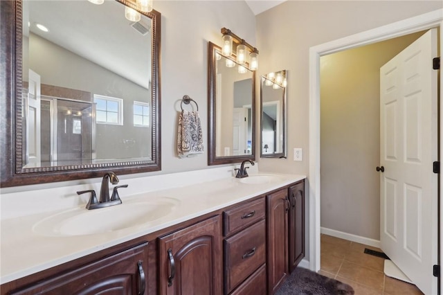 bathroom with a stall shower, tile patterned flooring, a sink, and double vanity