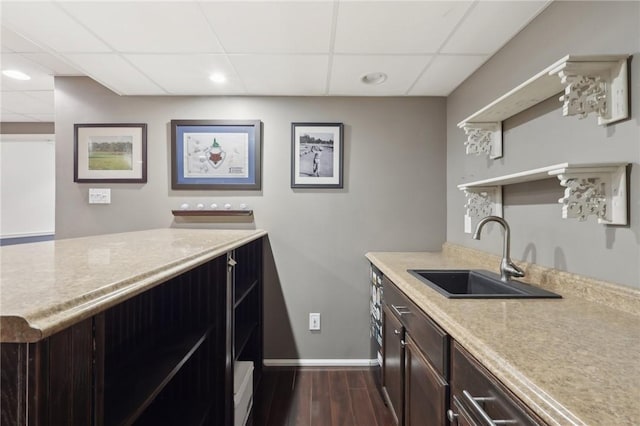 kitchen with dark wood-style flooring, a sink, baseboards, dark brown cabinets, and open shelves