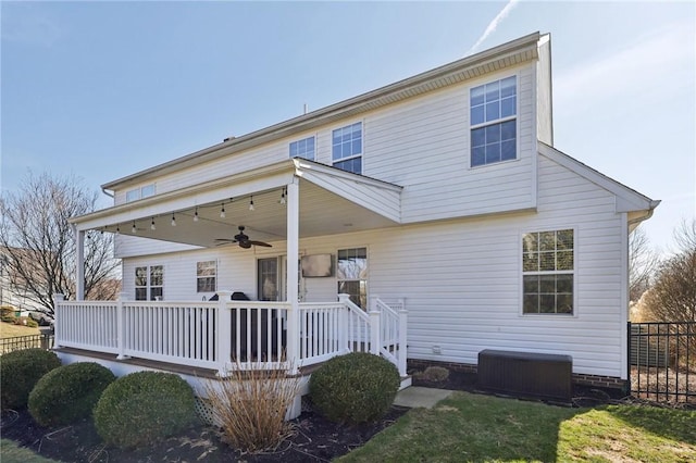 view of front of home with central AC, fence, and a ceiling fan