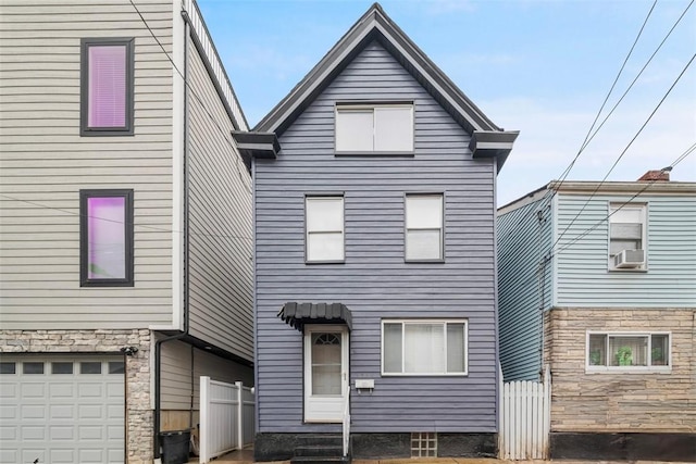 view of front of property featuring entry steps, an attached garage, fence, and cooling unit