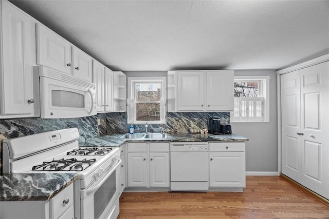 kitchen featuring light wood-type flooring, white appliances, white cabinets, and a sink