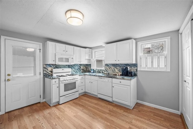 kitchen featuring white appliances, white cabinetry, and light wood finished floors