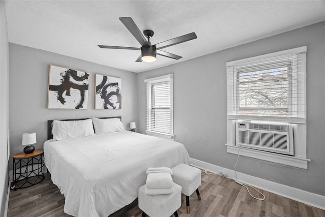 bedroom with cooling unit, baseboards, ceiling fan, and wood finished floors