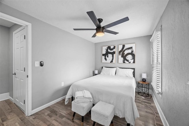 bedroom with a ceiling fan, baseboards, and wood finished floors