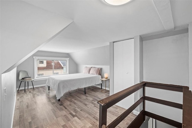 bedroom featuring vaulted ceiling, wood finished floors, and baseboards